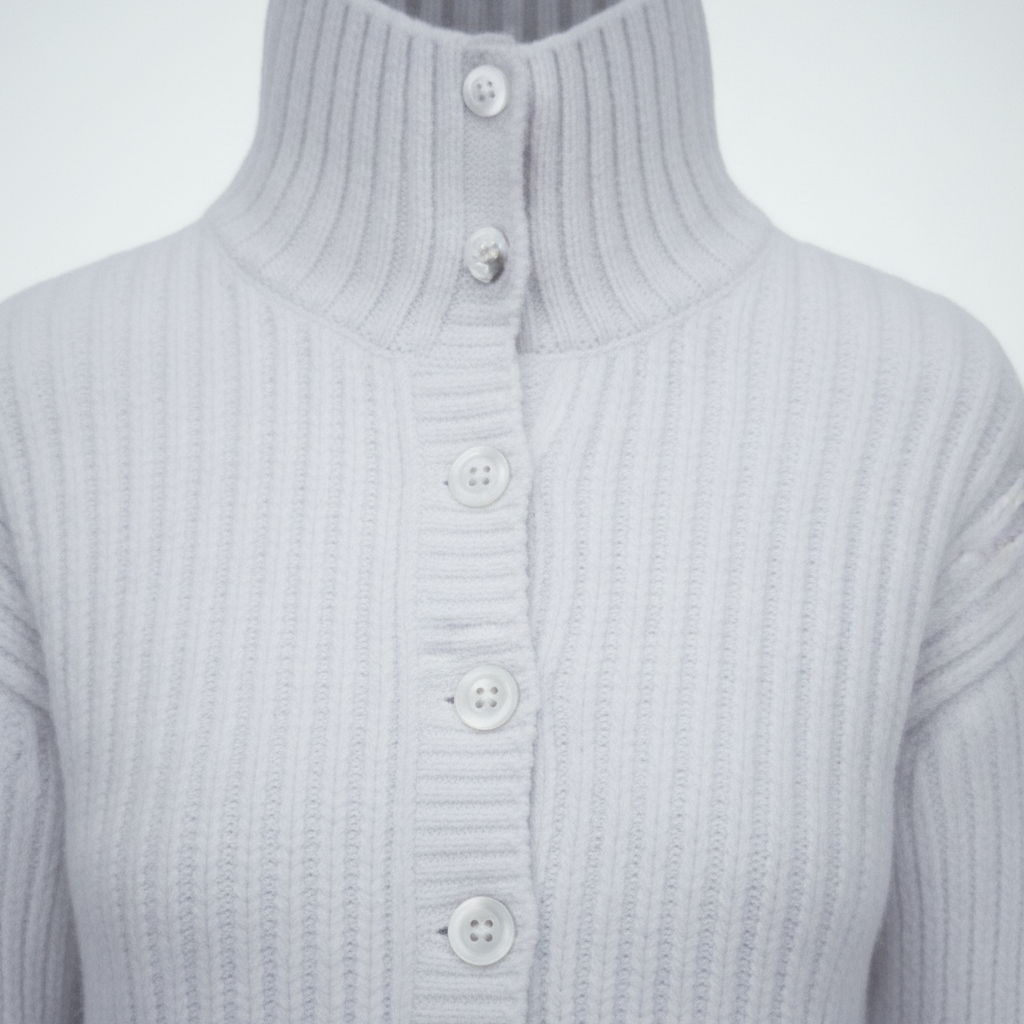 Close-up of white ribbed knit texture and buttons